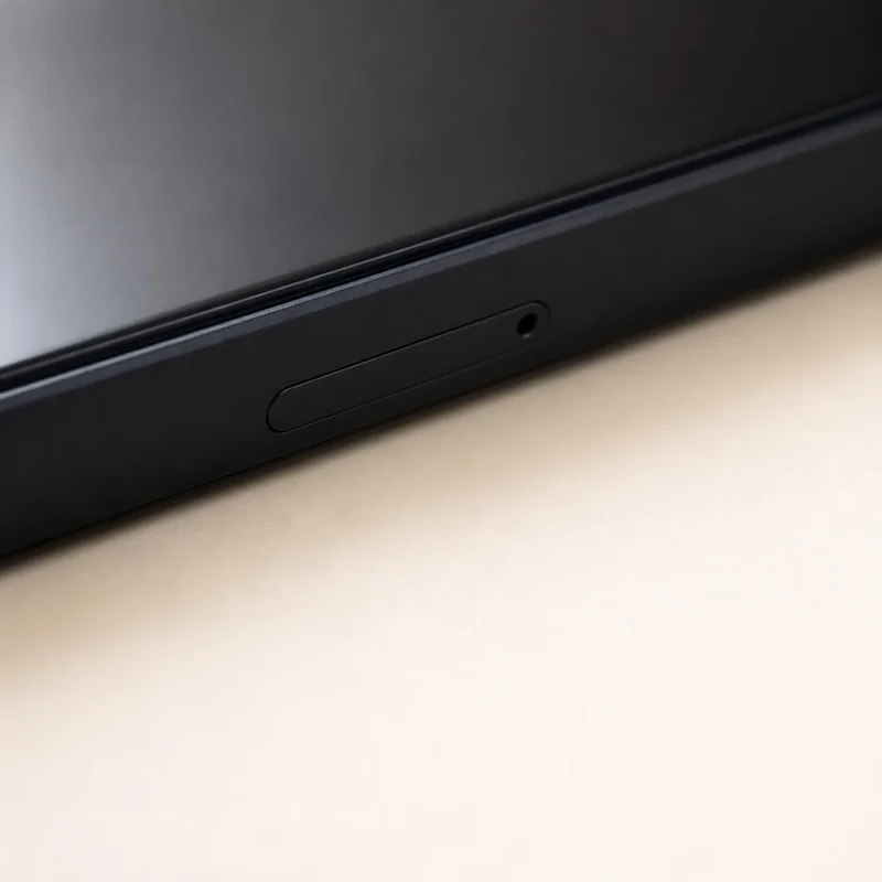 Close-up of the phone edge showing the small SIM tray pin hole